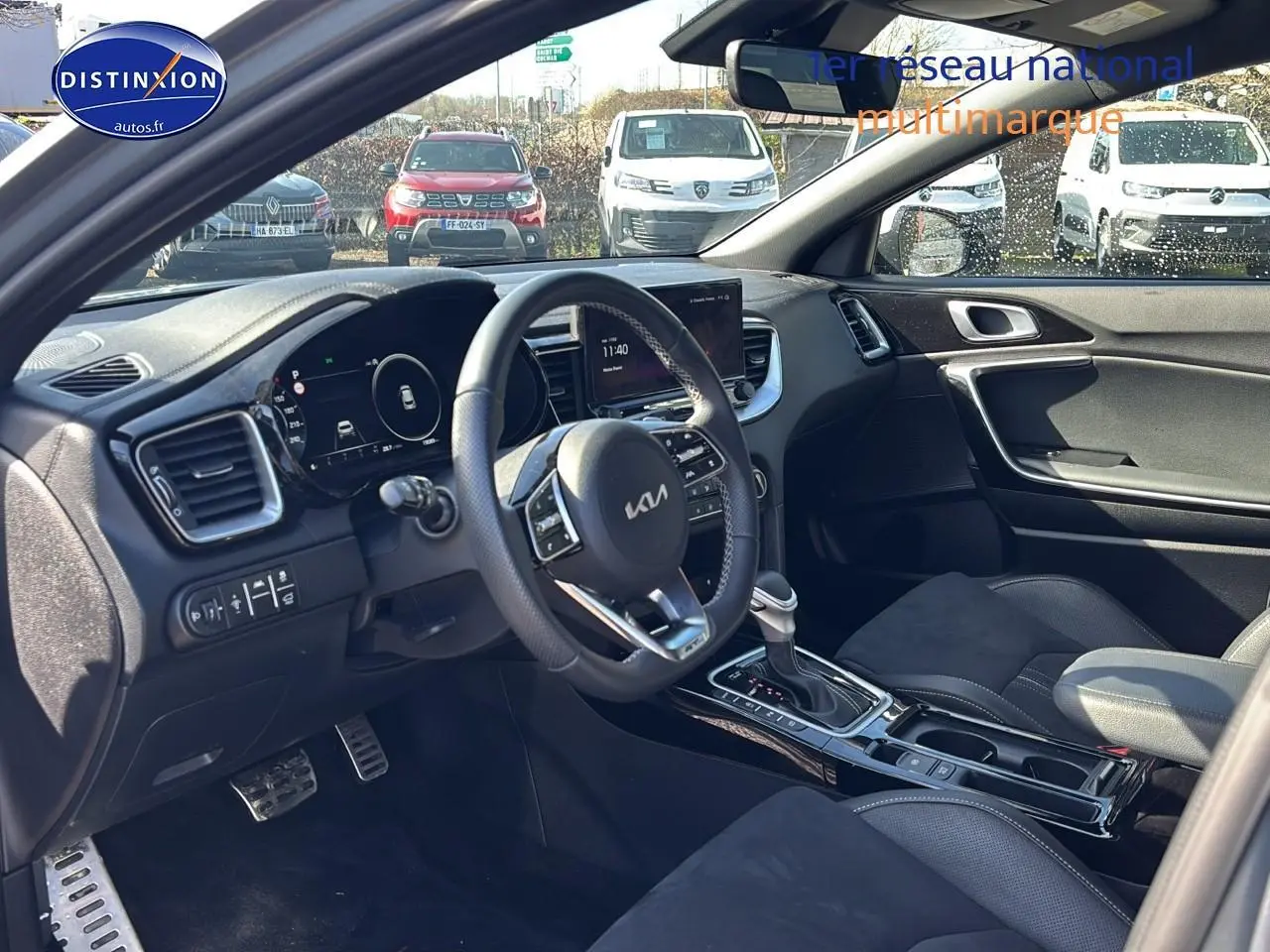 Vue intérieure côté conducteur du Kia Xceed gris 2024, volant cuir multifonction et console centrale avec boîte auto.