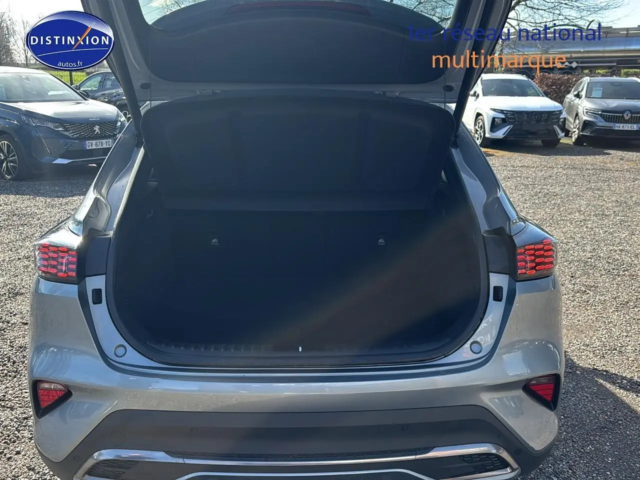 Vue arrière ouverte du coffre d’un KIA Xceed gris 2024, avec feux arrière LED et hayon relevé.