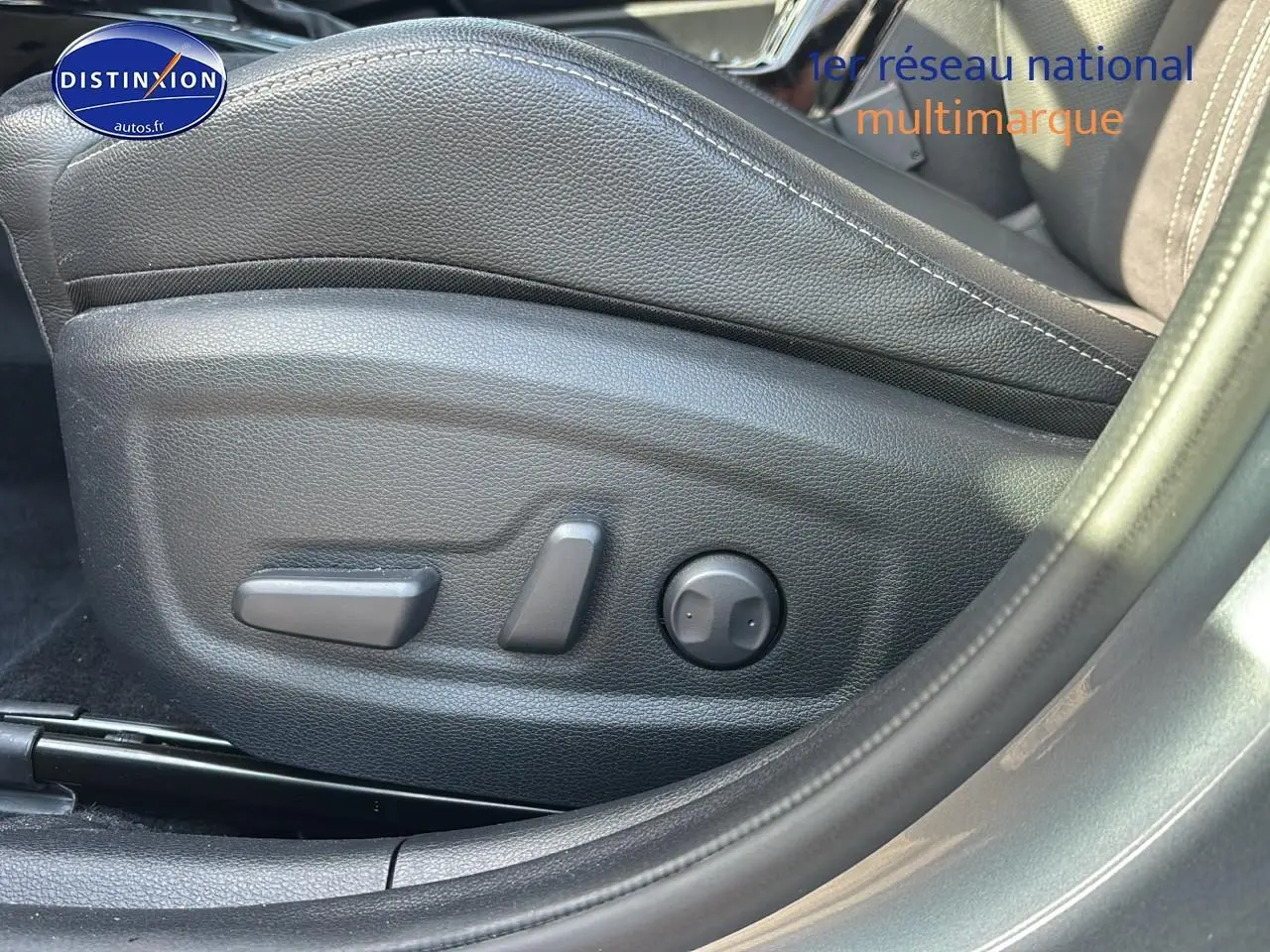 Détail des commandes électriques du siège conducteur noir sur KIA Xceed gris, vue latérale côté gauche.