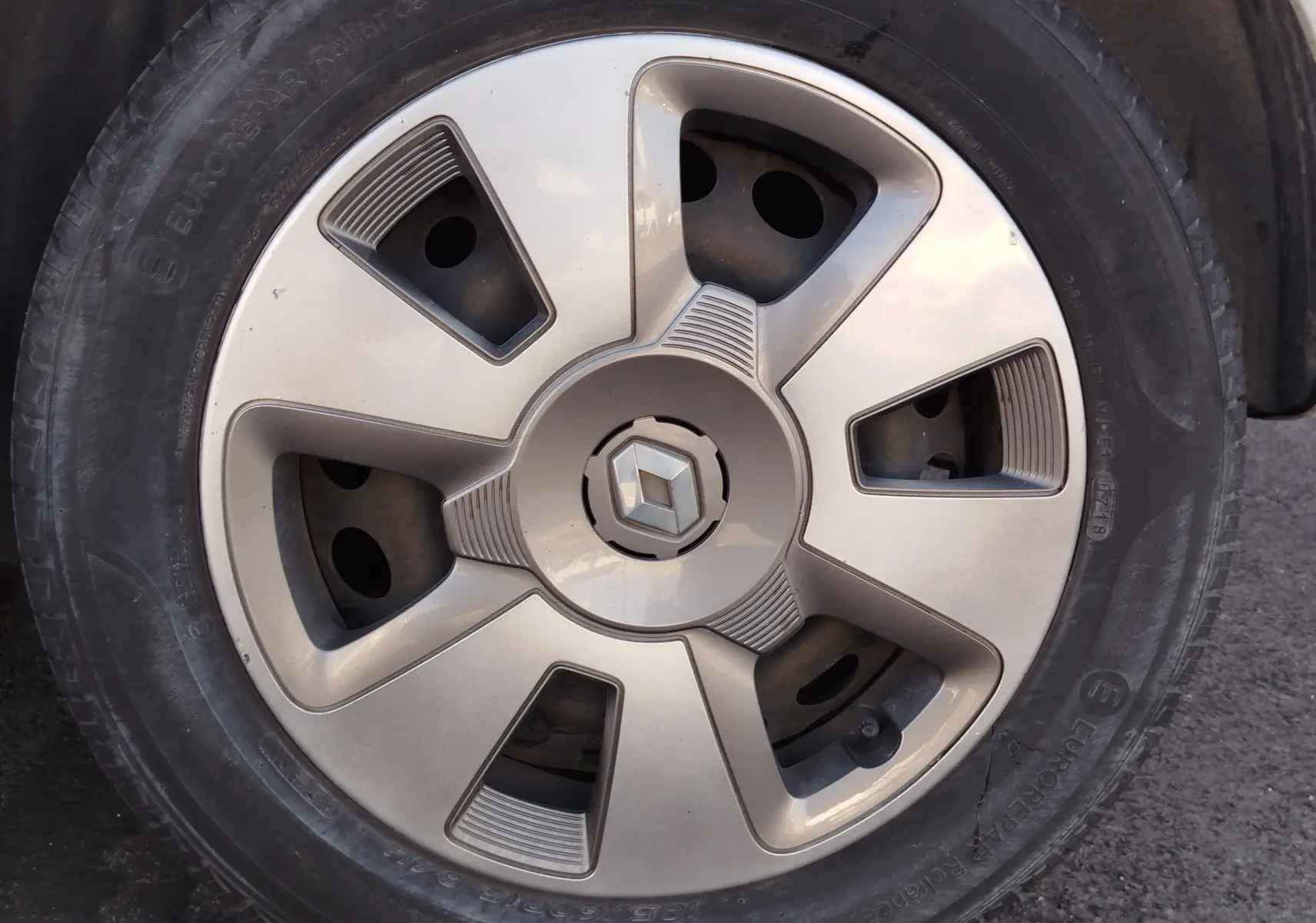 Gros plan sur la jante argentée d'une Renault Twingo Blanc Cristal, avec logo Renault au centre.