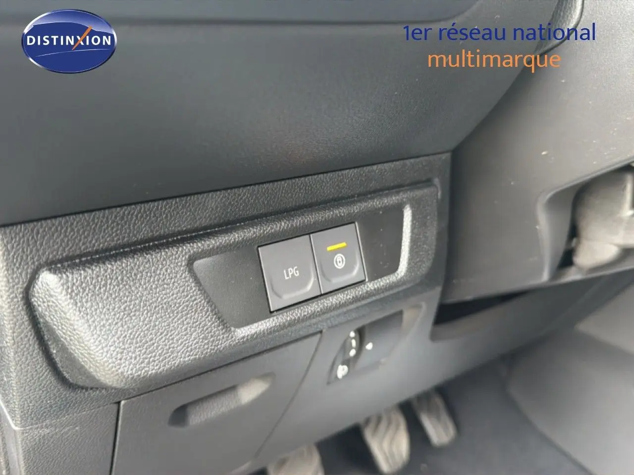 Gros plan sur les boutons LPG et frein de stationnement électrique dans l'habitacle du Dacia Jogger vert cèdre métal.