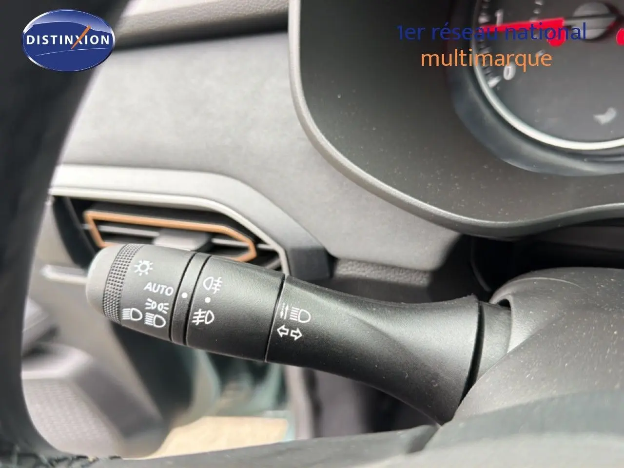 Gros plan sur la commande des phares et clignotants du tableau de bord intérieur du Dacia Jogger vert cèdre métal.