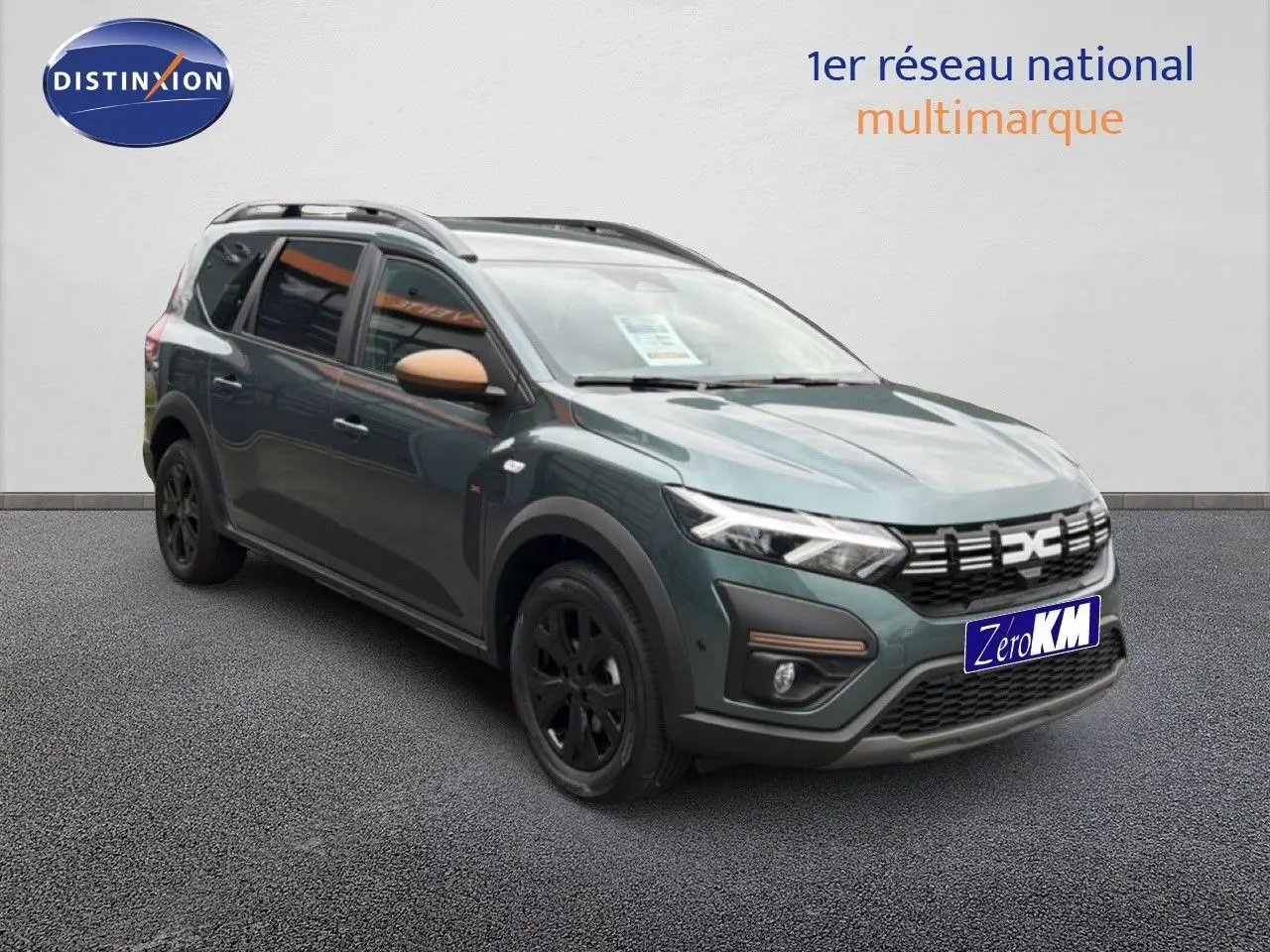 Vue 3/4 avant gauche d'une Dacia Jogger 2026 vert cèdre métallisé avec rétroviseurs couleur beige et jantes noires.
