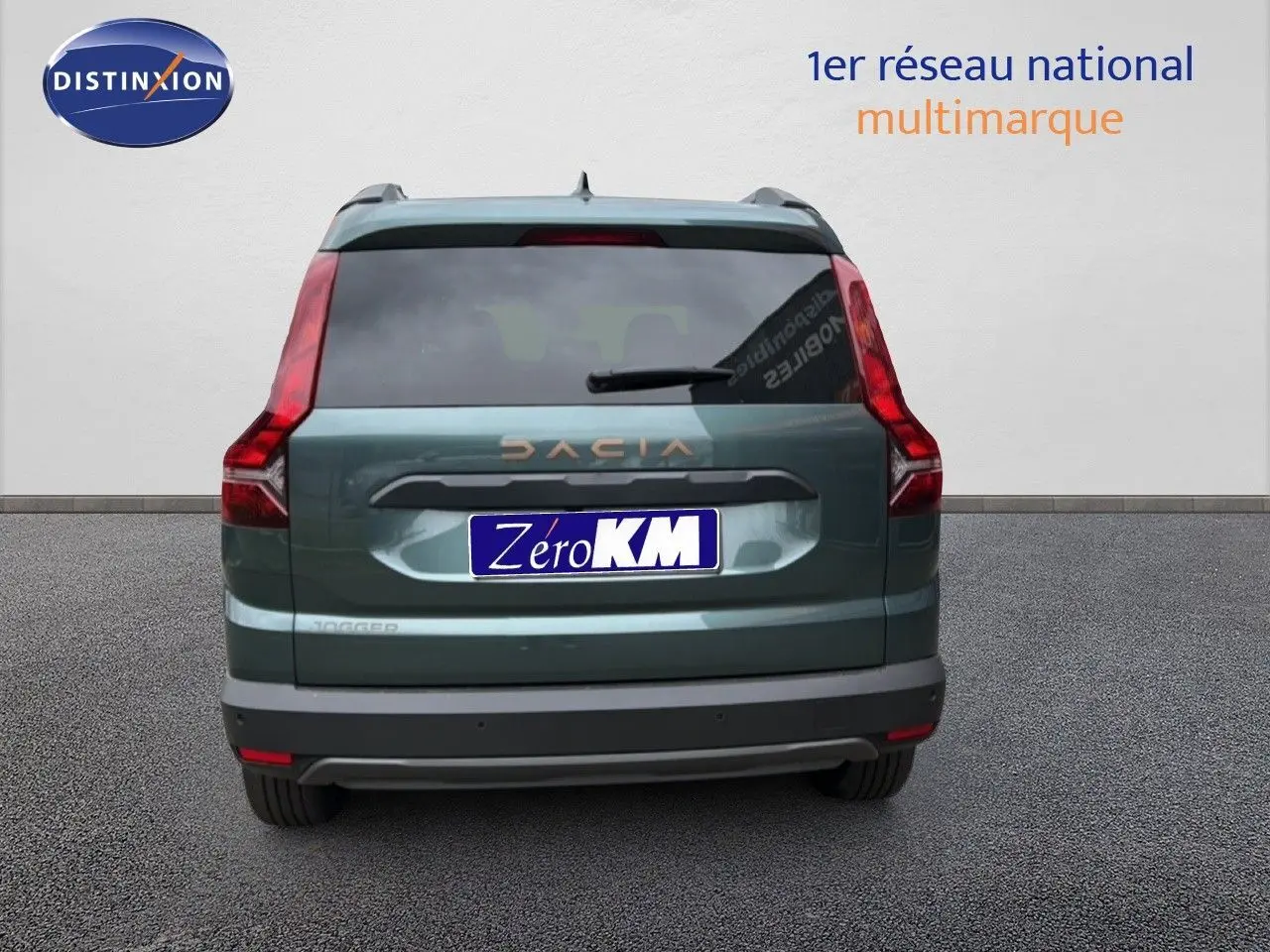 Vue arrière d'un Dacia Jogger vert cèdre métal avec feux arrière en L et logo DACIA visible.