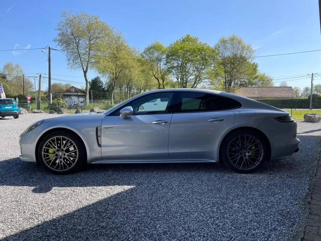 Vue latérale droite d'une Porsche Panamera 4 V6 3.0 Hybrid Platinum Edition gris métallisé, avec jantes sport et freins verts.