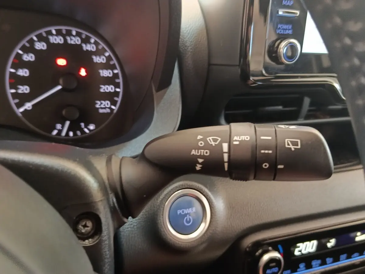 Gros plan intérieur sur la commande d’essuie-glace et bouton Power d’une Toyota Yaris Hybride blanche de 2022.