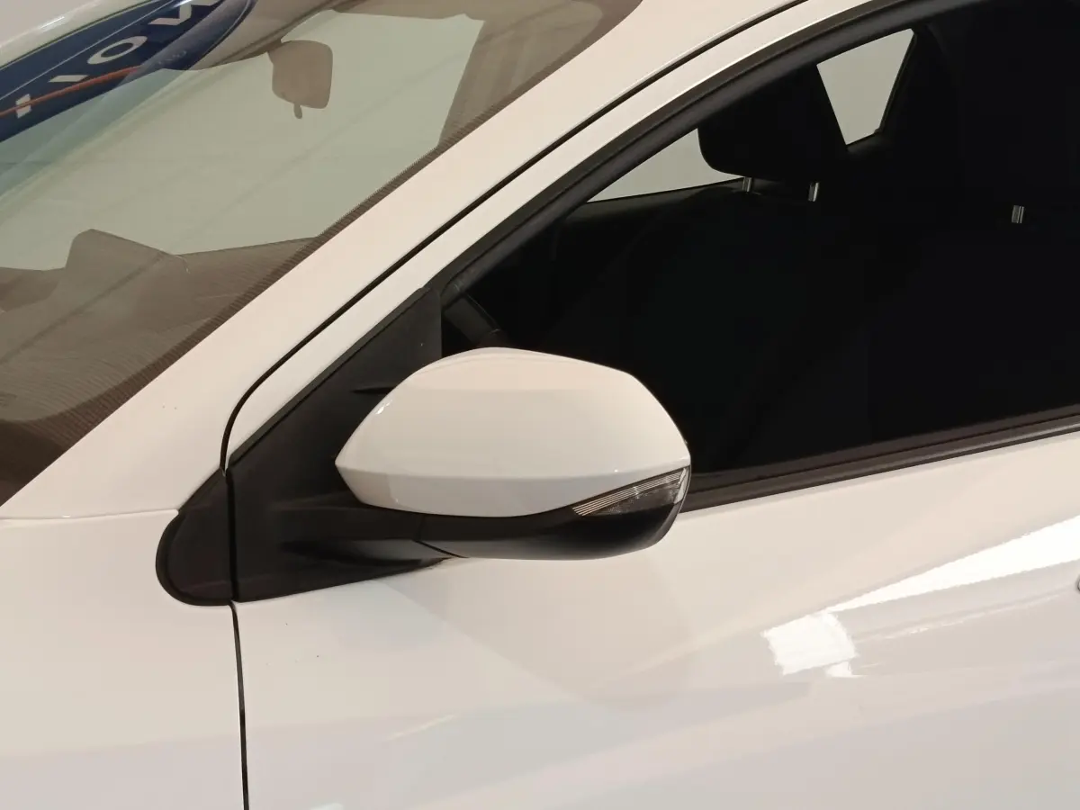 Rétroviseur côté gauche blanc de la Toyota Yaris Hybride 2022, vue rapprochée sur la portière avant.