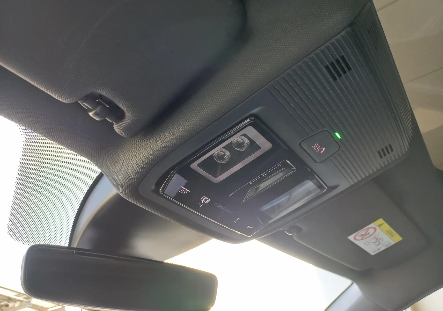 Vue intérieure du plafonnier noir avec commandes d'éclairage et bouton SOS du CUPRA Leon 2025 toit ouvrant panoramique.