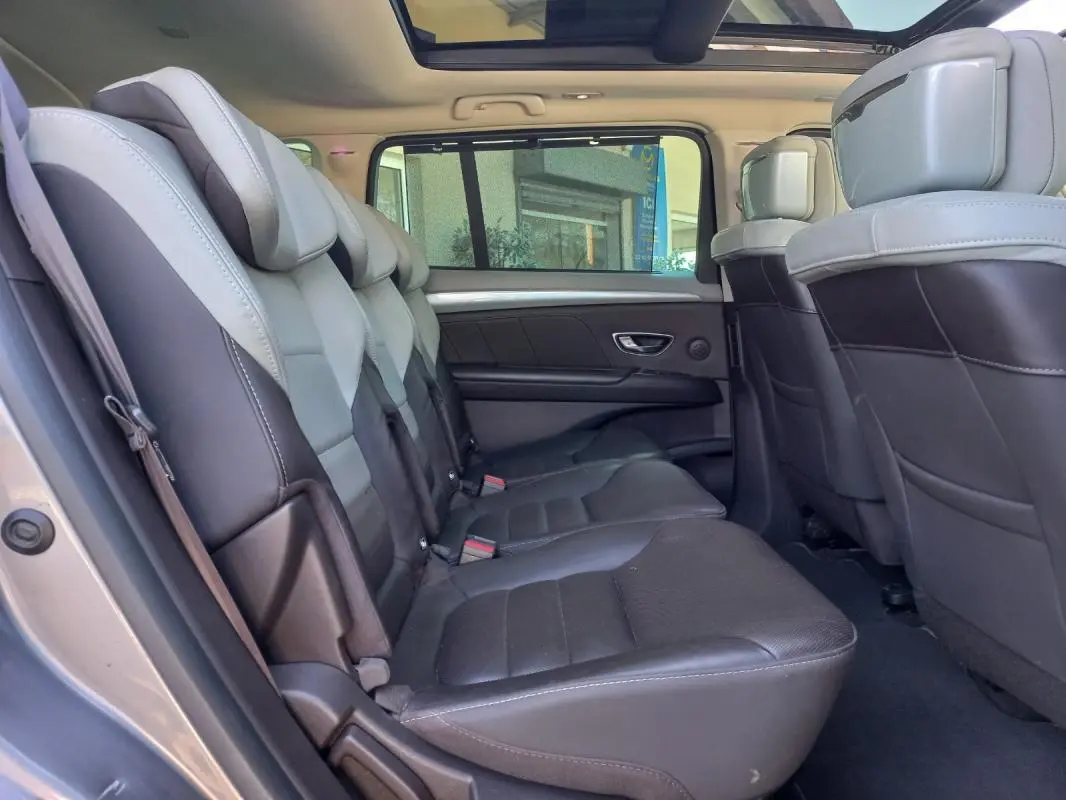 Vue intérieure côté gauche du Renault Espace gris 2017, montrant les sièges arrière en cuir bicolore et le toit panoramique.