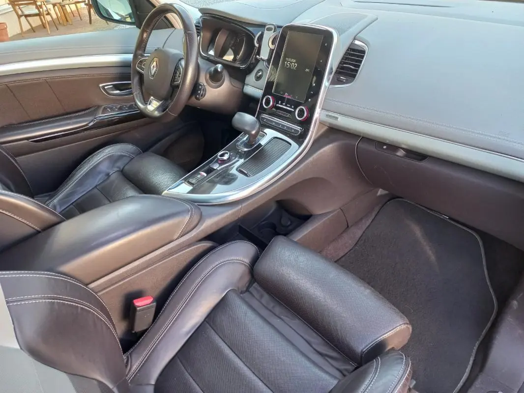 Vue intérieure côté conducteur du Renault Espace gris 2017, mettant en valeur le tableau de bord et la console centrale tactile.