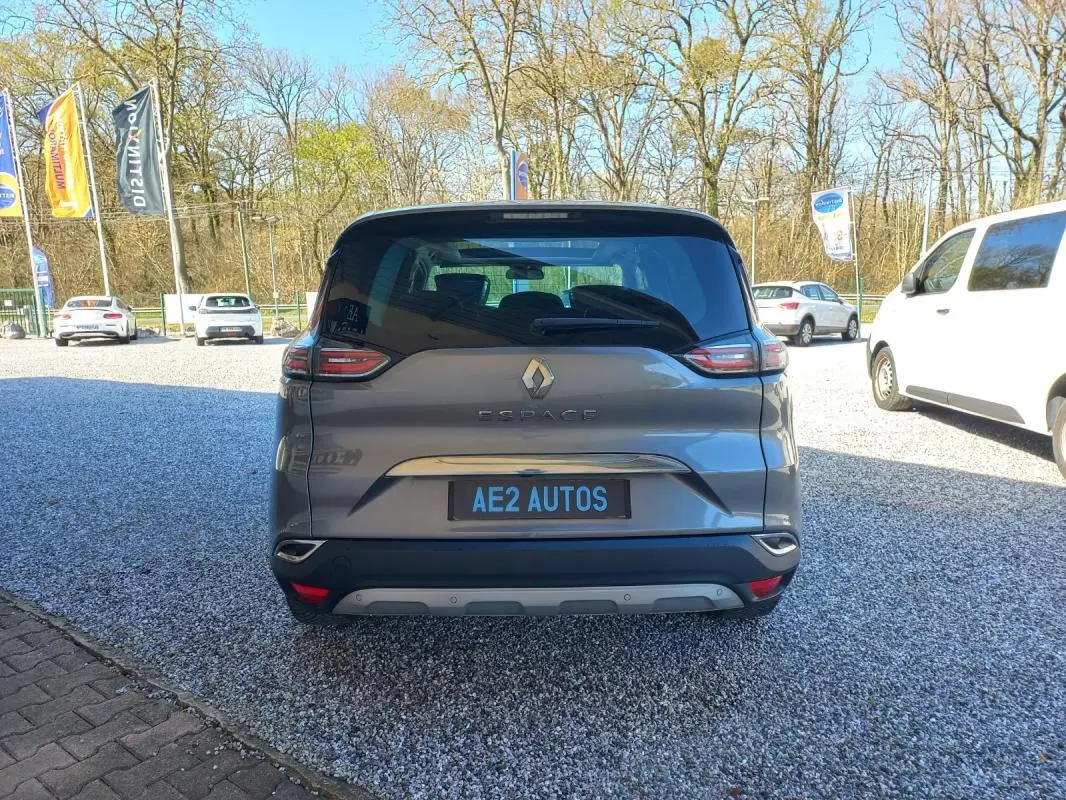 Vue arrière du Renault Espace gris 2017, mettant en valeur ses feux distinctifs et son logo central sur un parking extérieur.