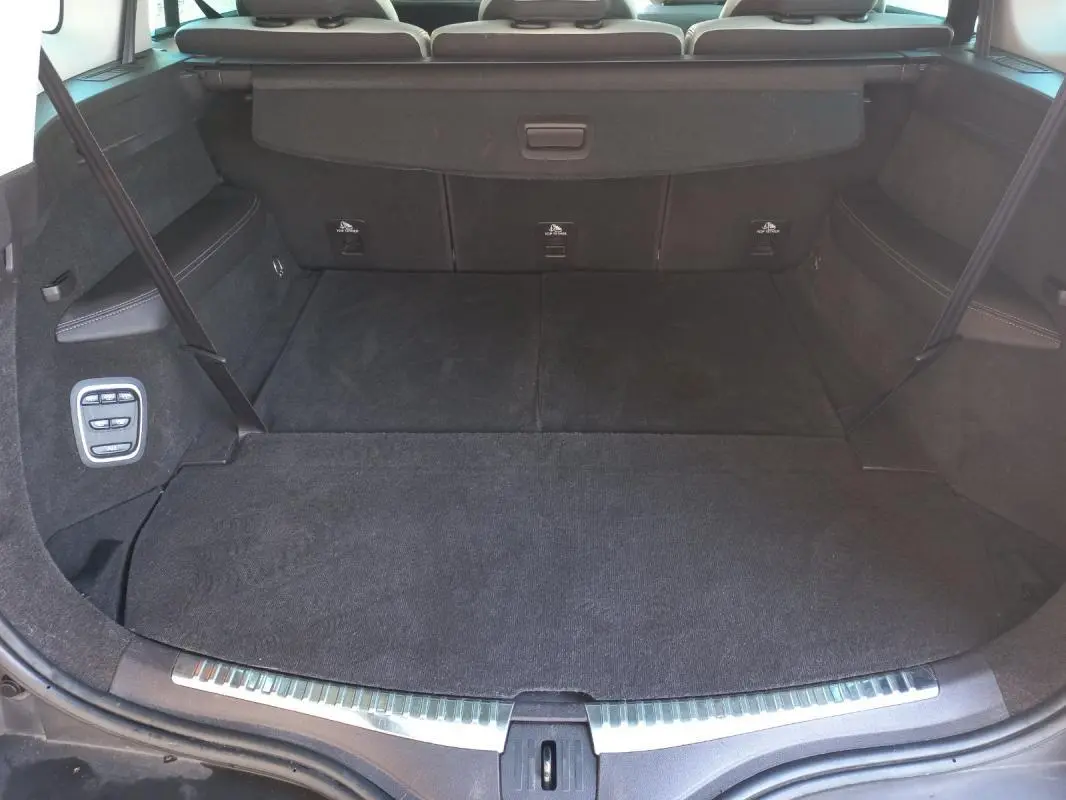 Coffre ouvert du Renault Espace gris 2017, vue arrière montrant un espace de chargement spacieux avec commandes latérales.