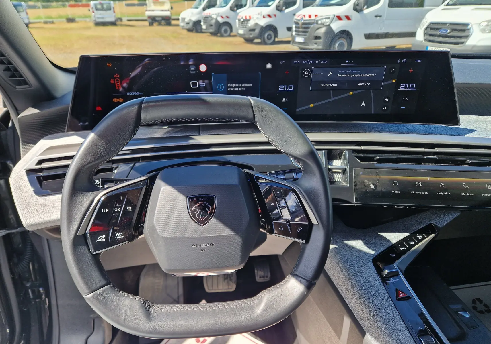 Vue intérieure centrée sur le volant cuir et le tableau de bord numérique du Peugeot 3008 gris titane 2026.