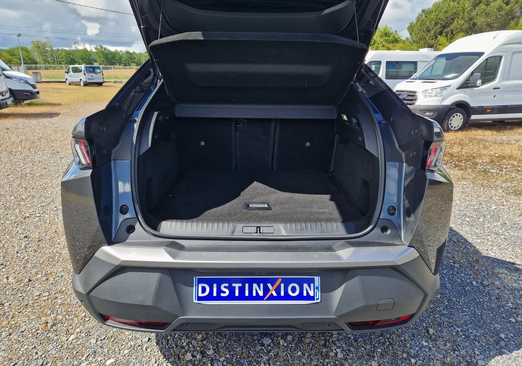 Vue arrière ouverte du coffre du Peugeot 3008 gris titane, montrant l'espace de chargement vide et le hayon relevé.