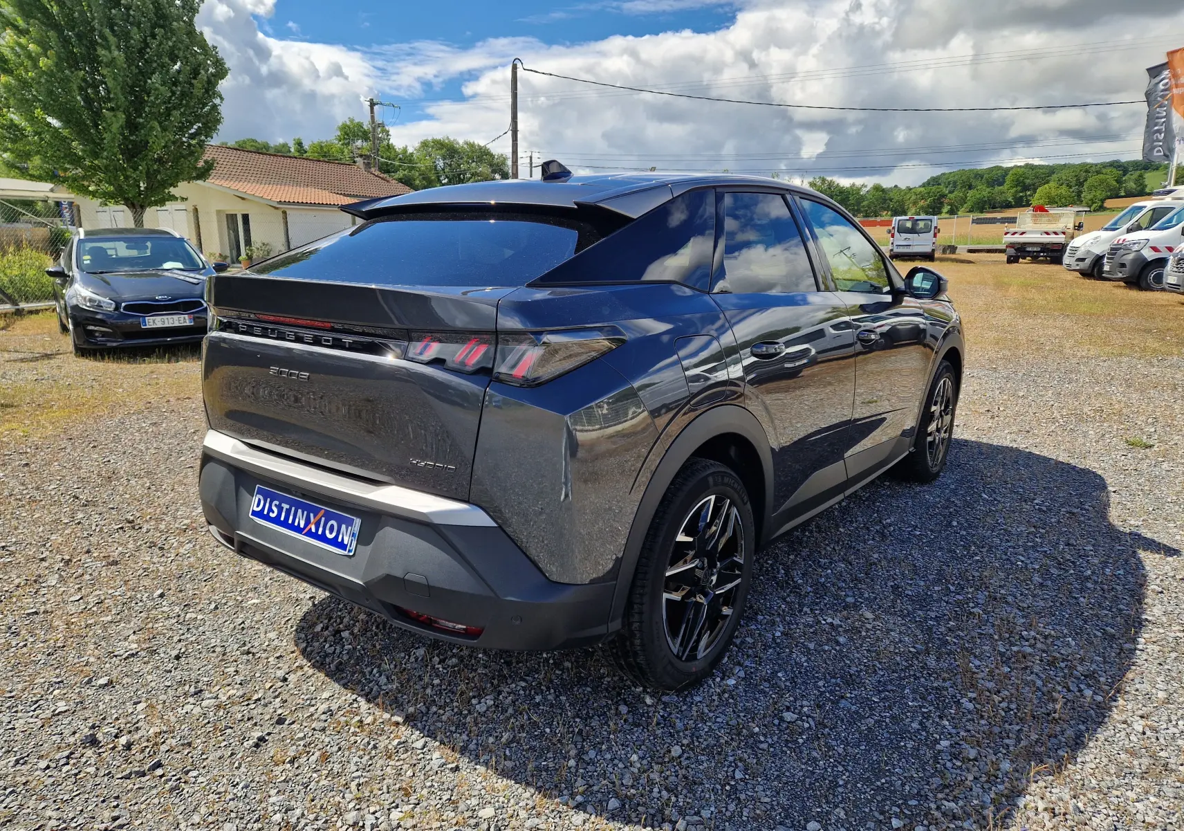 Peugeot 3008 gris titane vue 3/4 arrière droit sur parking, avec jantes noires et vitres teintées.