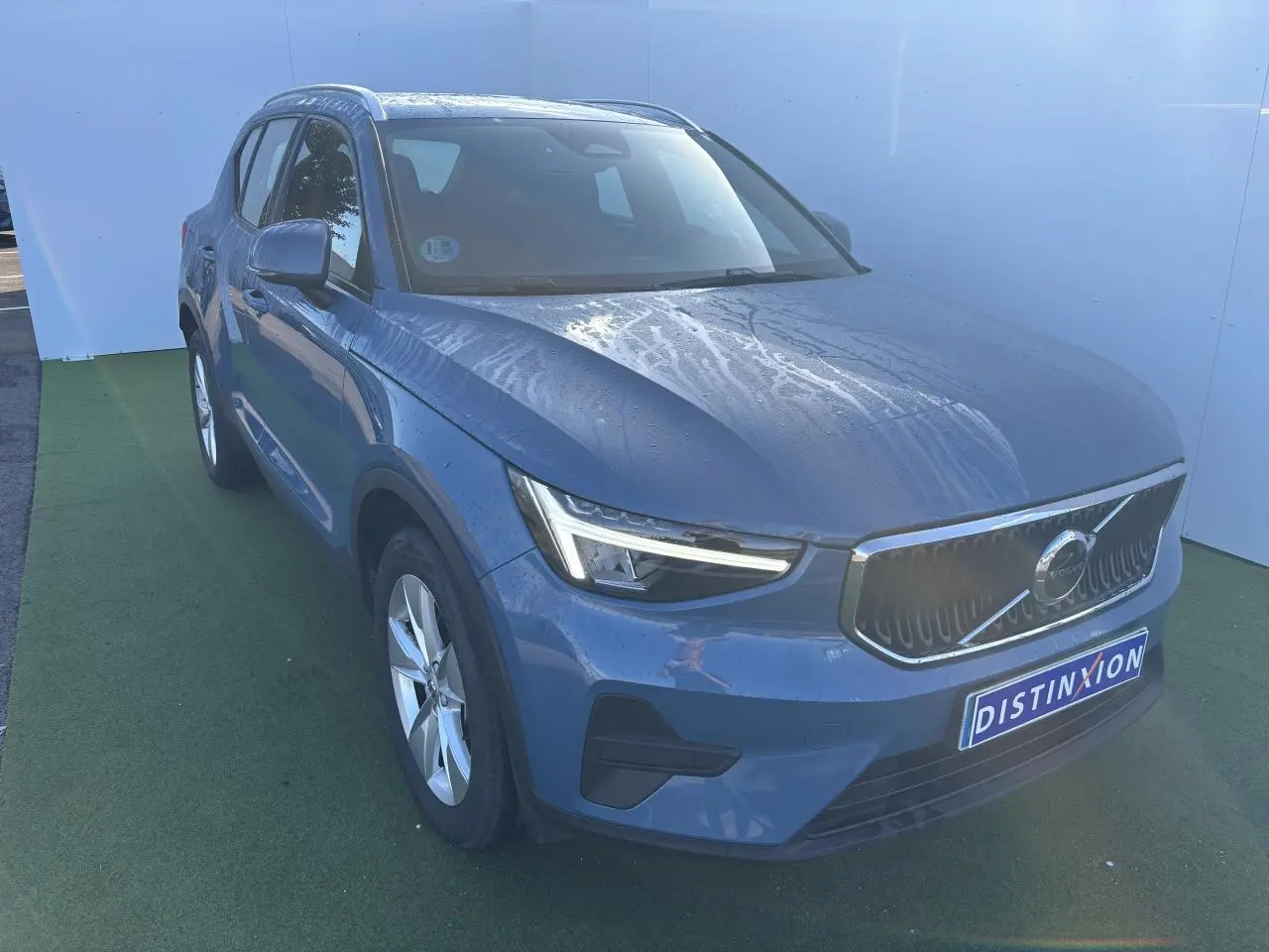 Volvo XC40 Fjord Blue métal vue 3/4 avant avec calandre chromée et feux LED en forme de marteau.
