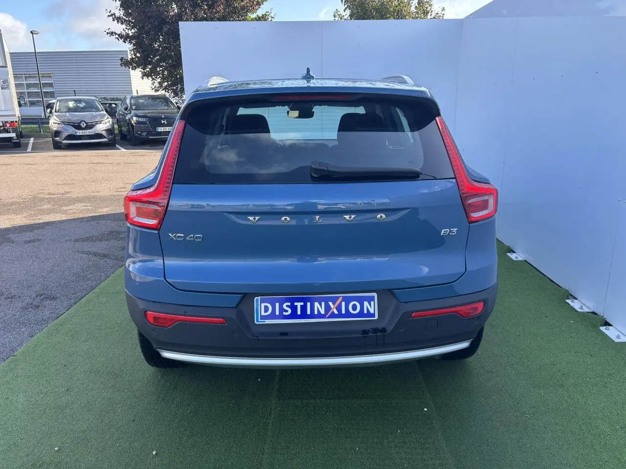 Vue arrière d'un Volvo XC40 B3 Fjord Blue Metal 2024 avec feux arrière en forme de L et plaque Distinxion.