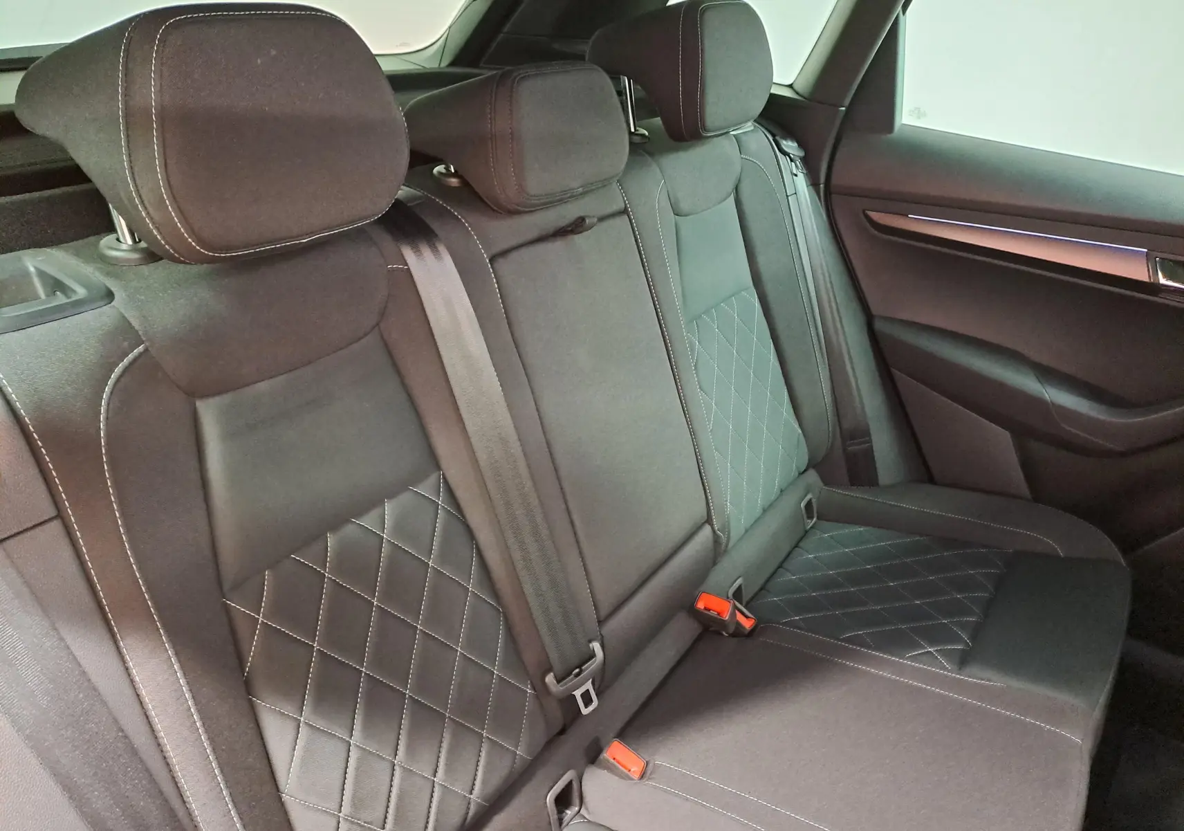 Vue intérieure des sièges arrière en tissu noir avec surpiqûres blanches du Skoda Karoq 2.0 TDI 150 DSG7 Sportline.