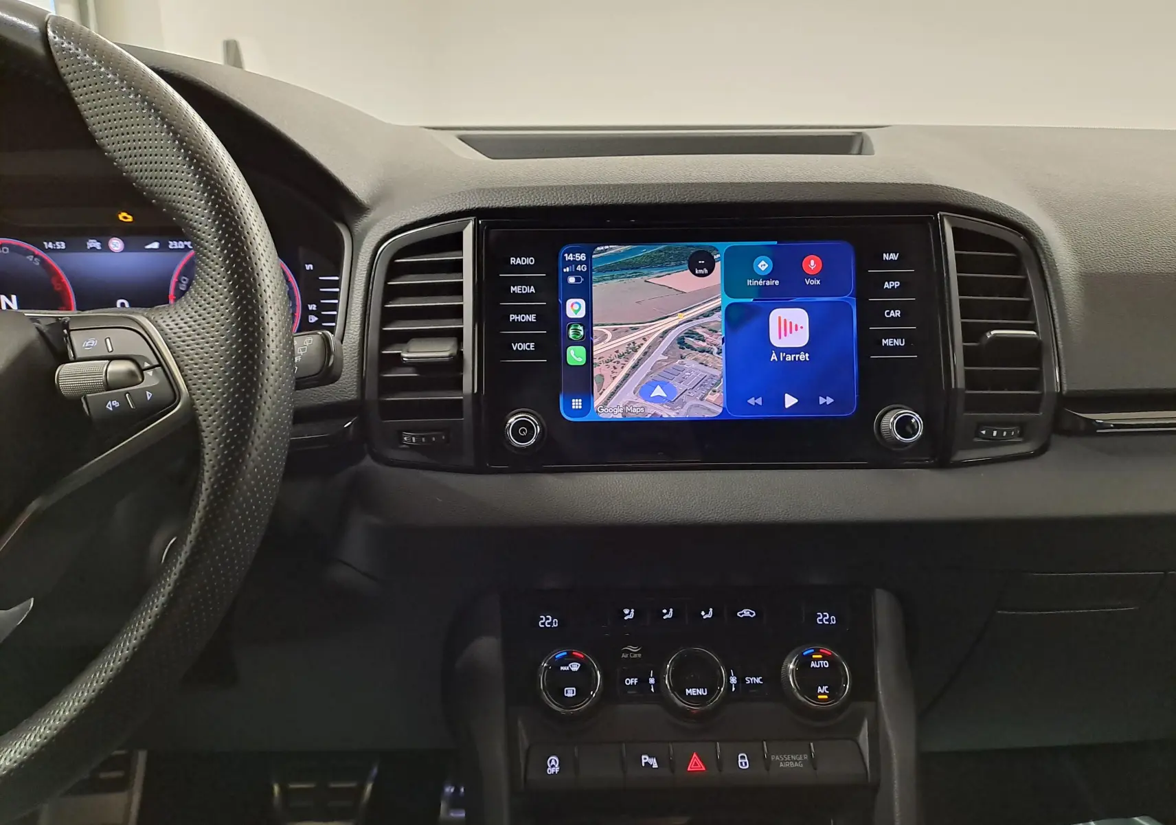 Vue intérieure du tableau de bord du Skoda Karoq 2025 avec écran tactile central affichant la navigation et commandes climatisation.