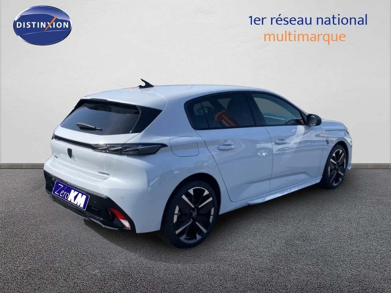 Vue 3/4 arrière droite d'une Peugeot 308 Hybrid blanche Okenite avec jantes noires et vitres teintées.