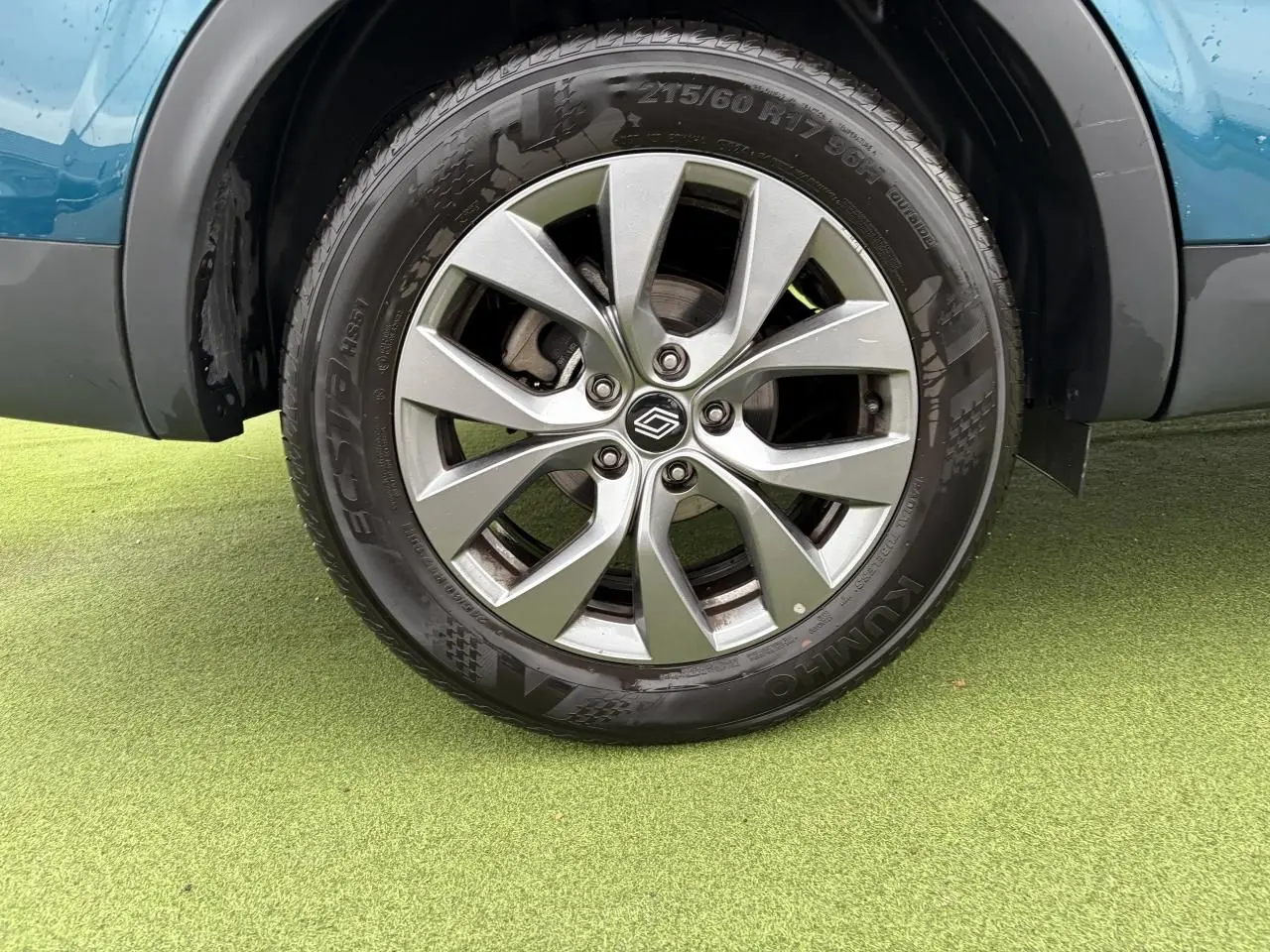 Gros plan sur la roue avant droite avec jante alliage grise 17 pouces du Renault Arkana Bleu Zanzibar.