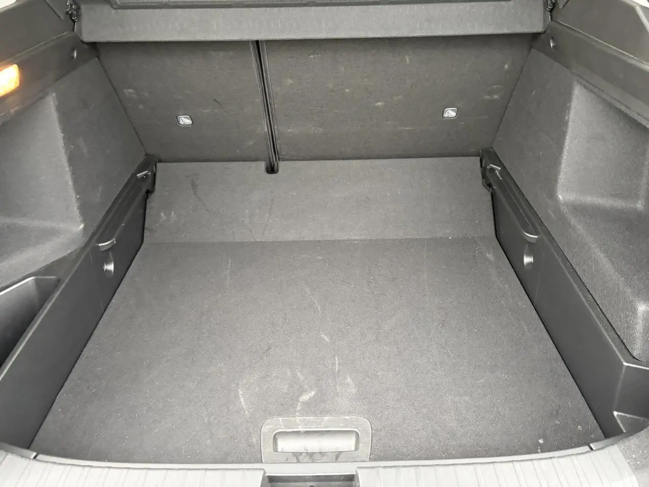 Coffre vide en vue plongeante d'un Renault Arkana 2025, intérieur tissu gris foncé, plancher plat amovible.