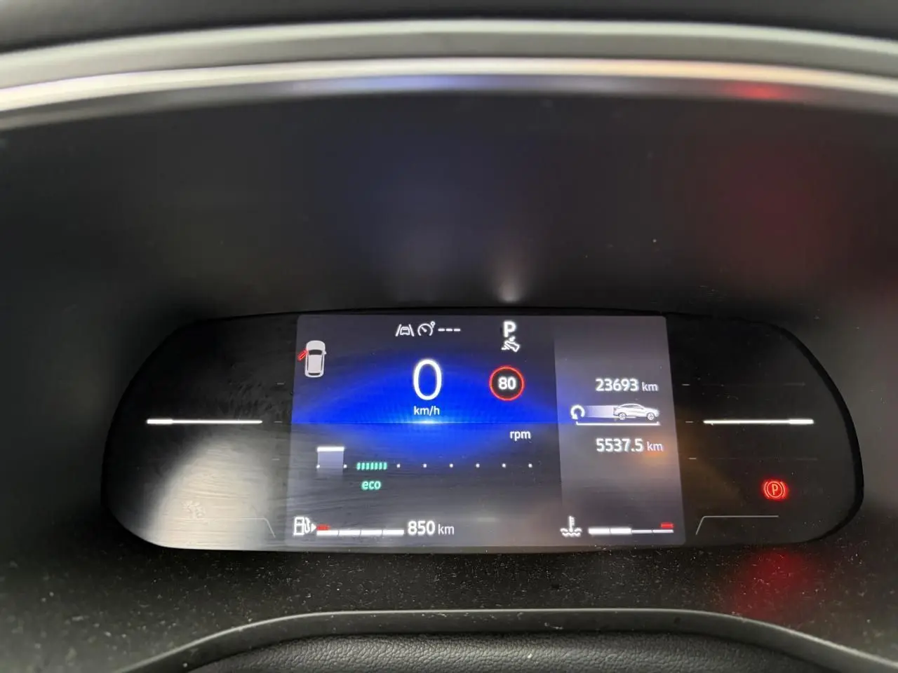 Tableau de bord numérique de Renault Arkana 2025 affichant vitesse zéro et indicateurs de conduite en vue frontale.