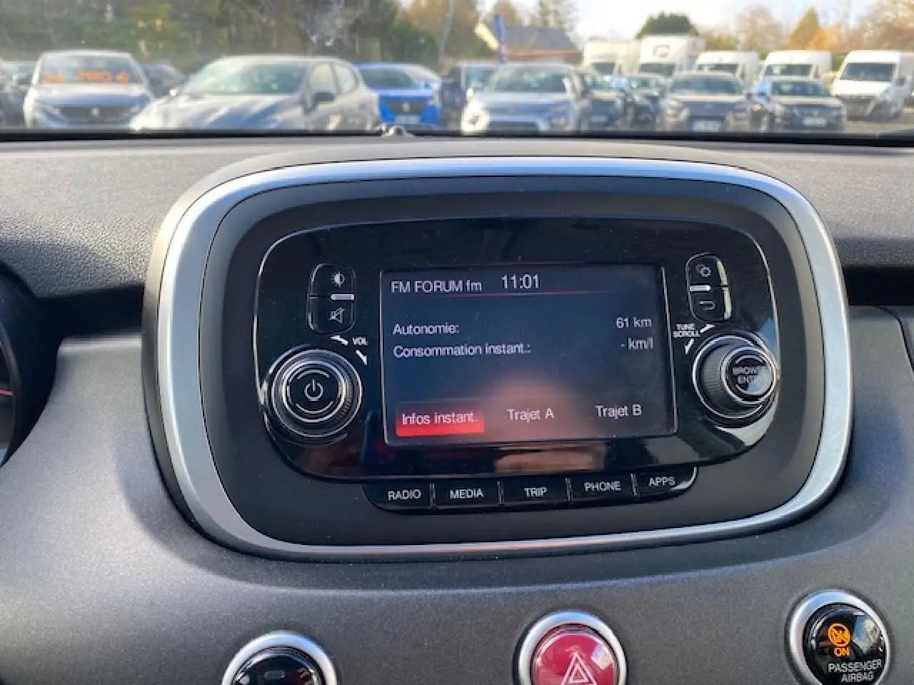 Écran central tactile du tableau de bord du Fiat 500X noir, affichant les options radio et autonomie.