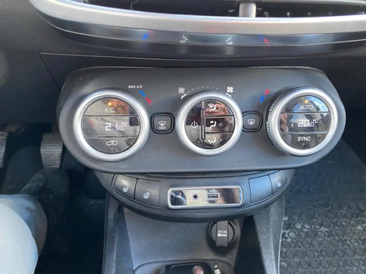 Tableau de bord de Fiat 500X Cross 2016 noir, vue centrée sur les commandes de climatisation avec affichage digital.