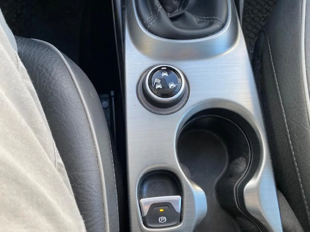 Vue rapprochée de la console centrale du Fiat 500X noir 2016, avec sélecteur de modes de conduite et frein à main électrique.