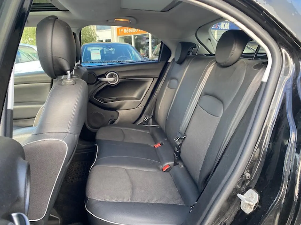 Vue intérieure côté droit des sièges arrière noirs en tissu et cuir du Fiat 500X Cross 2016.