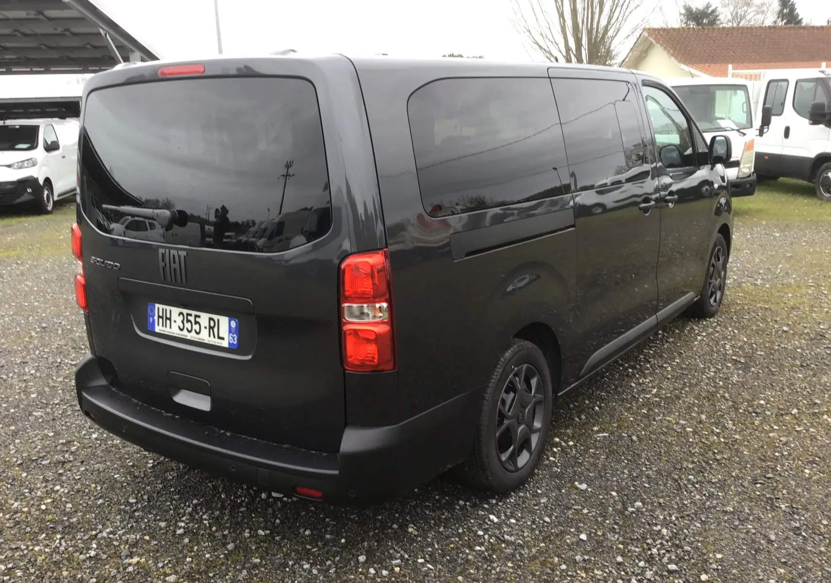Vue 3/4 arrière droite d’un FIAT Scudo Combi gris titane avec vitres latérales surteintées et hayon arrière fermé.
