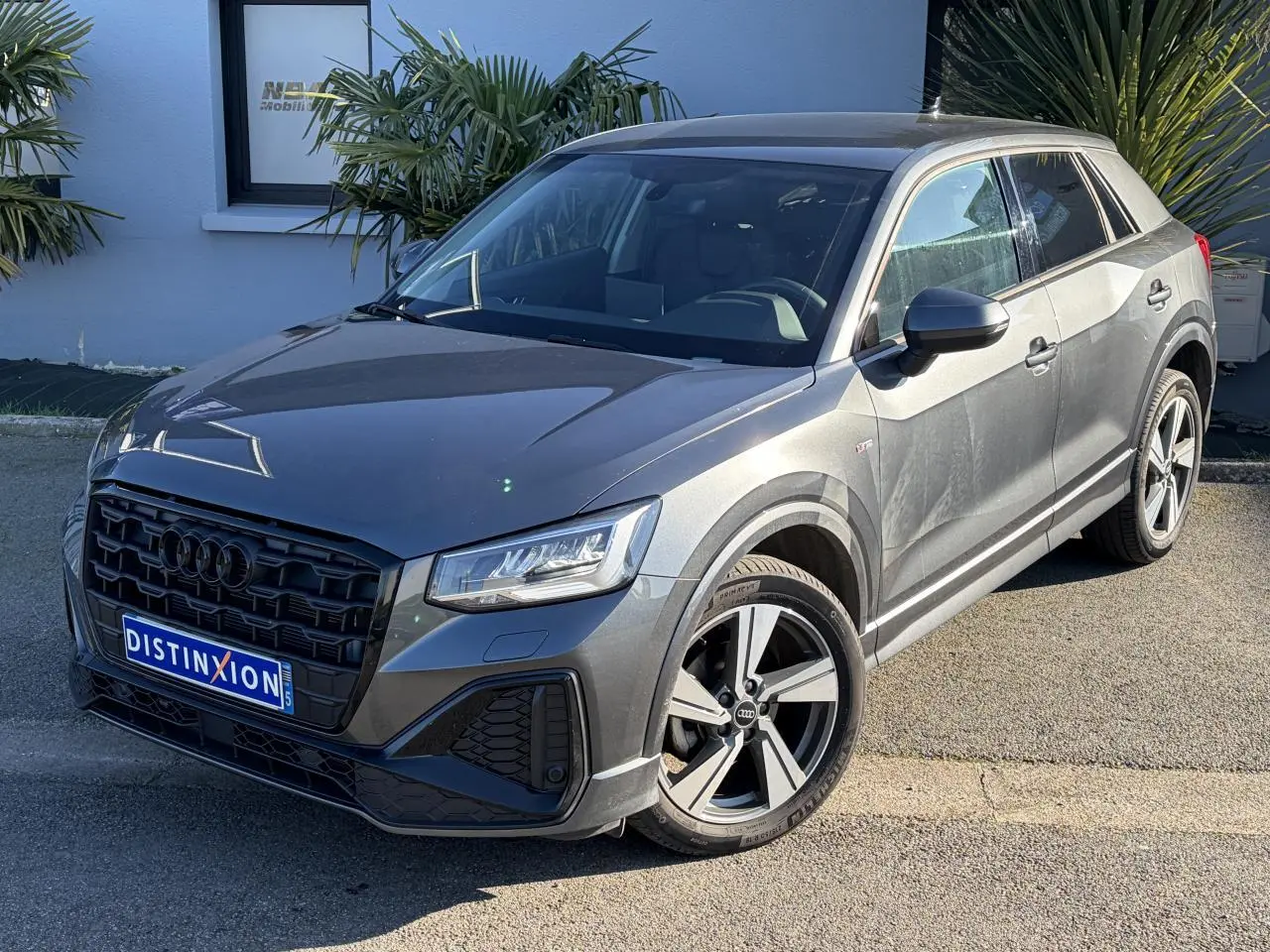 Audi Q2 gris Daytona en vue 3/4 avant droit, avec jantes alliage 18 pouces et calandre noire S line.