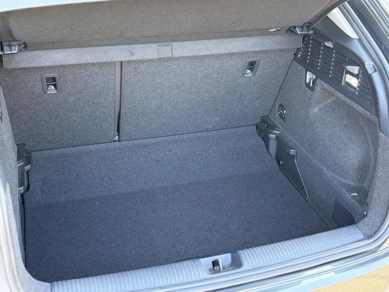 Coffre ouvert vu de face d’un Audi Q2 35 TFSI S-Line 2024, intérieur de coffre gris foncé sans chargement visible.