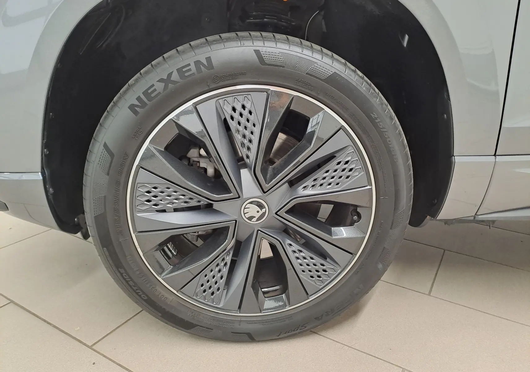 Gros plan sur la roue avant droite du Skoda Karoq gris graphite, mettant en valeur la jante alliage au design moderne.