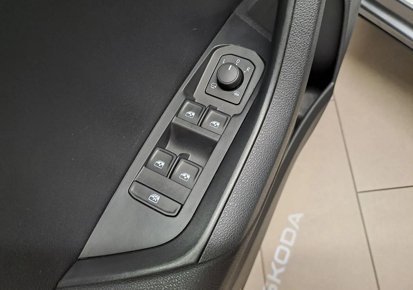 Commande des vitres et rétroviseurs sur la porte côté conducteur du Skoda Karoq gris graphite, vue en gros plan.