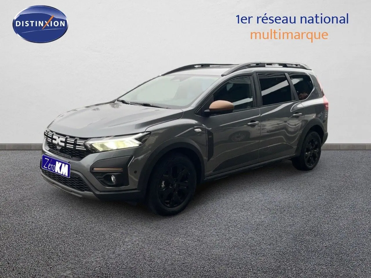 Dacia Jogger gris schiste métal en 3/4 avant droit avec jantes noires et rétroviseurs couleur cuivre.