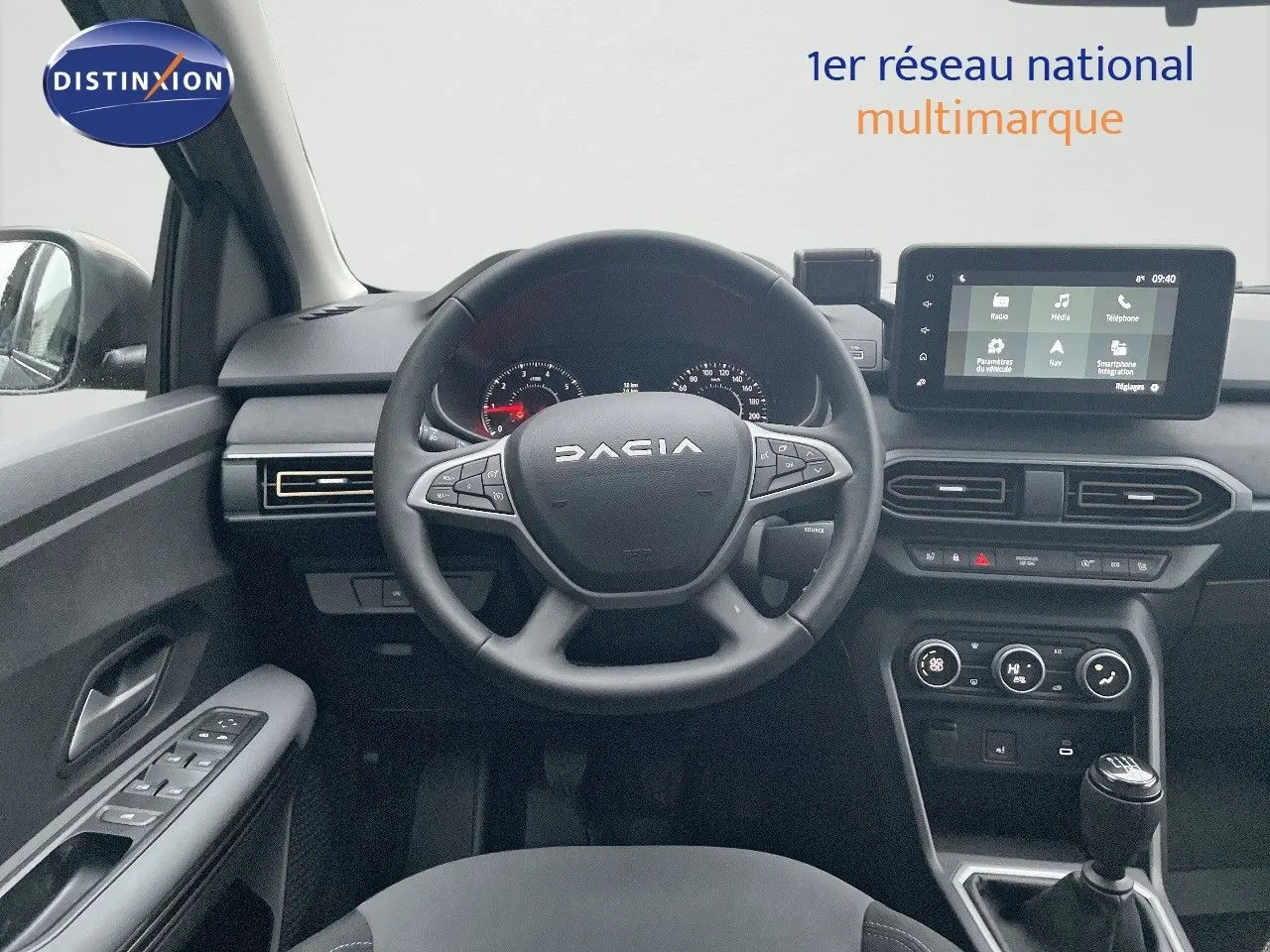 Vue intérieure frontale du poste de conduite du Dacia Jogger gris schiste, avec volant multifonction et écran tactile central.