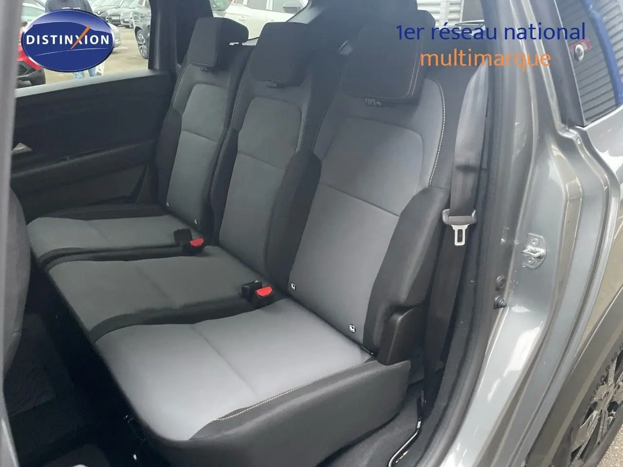 Vue latérale intérieure sur la banquette arrière grise du Dacia Jogger 2026, avec porte ouverte côté droit.