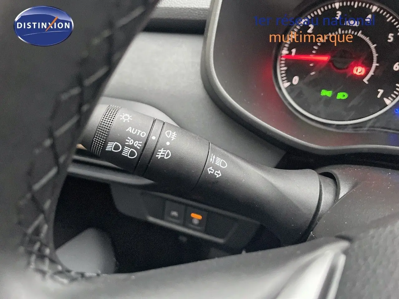 Gros plan sur la manette de phares et clignotants à gauche du volant d’un Dacia Jogger gris schiste 2026.