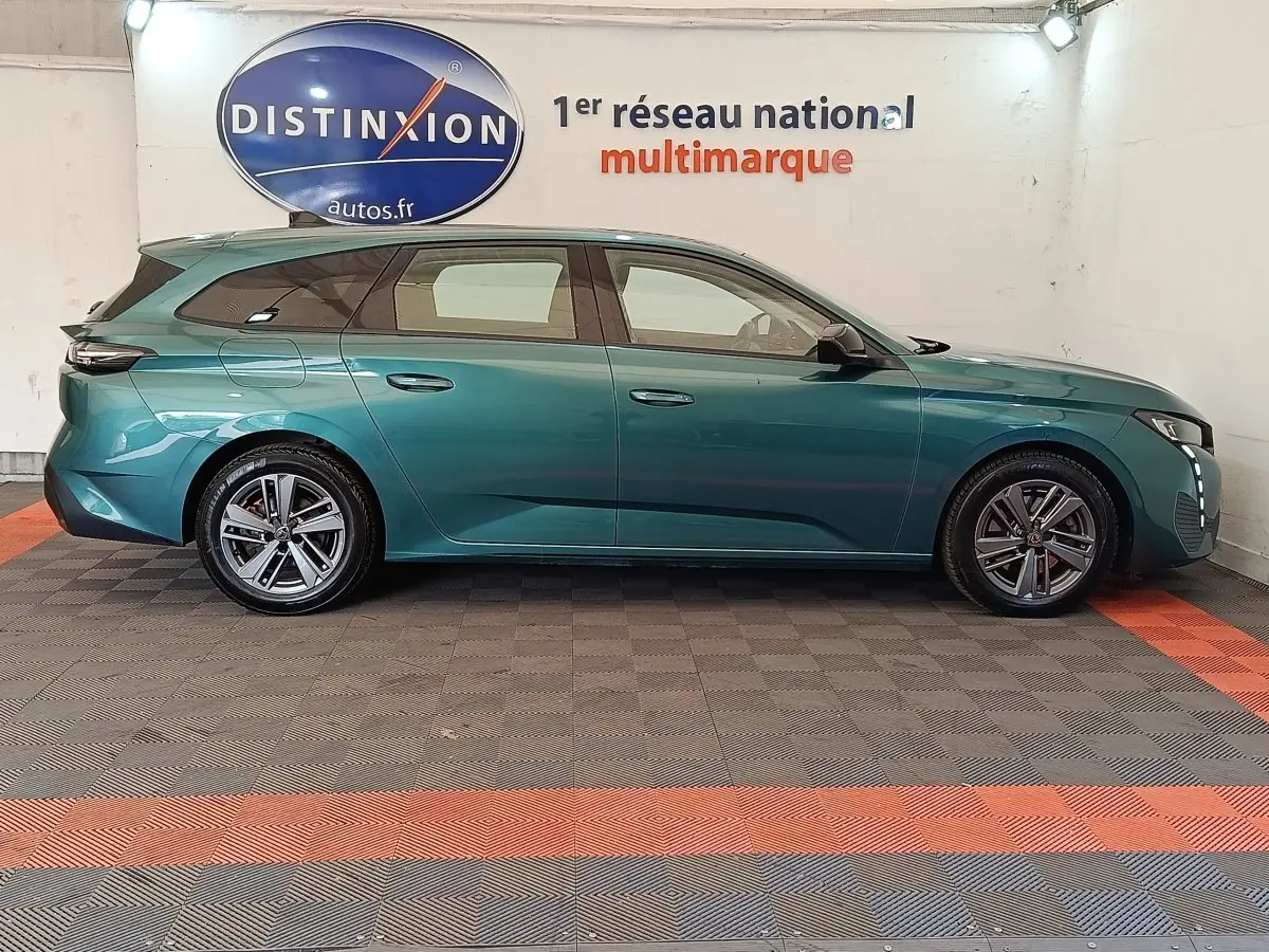 Peugeot 308 PureTech 130 2023 en break vert bleu, vue de profil côté gauche, avec jantes alliage et feux LED.