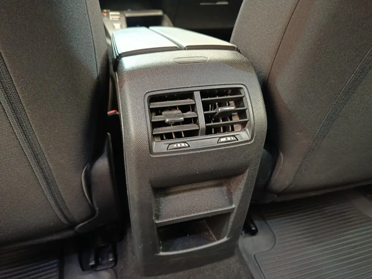 Gros plan sur la console arrière noire avec bouches d’aération et rangement entre les sièges arrière noirs du Peugeot 308 2023.