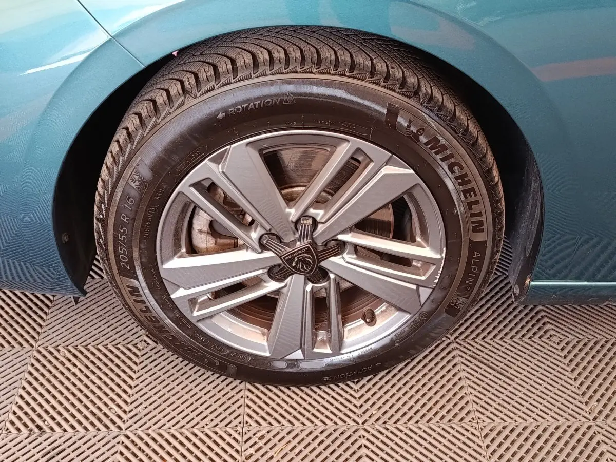 Gros plan sur la roue avant gauche d’une Peugeot 308 2023 bleue avec jante alliage et pneu Michelin.
