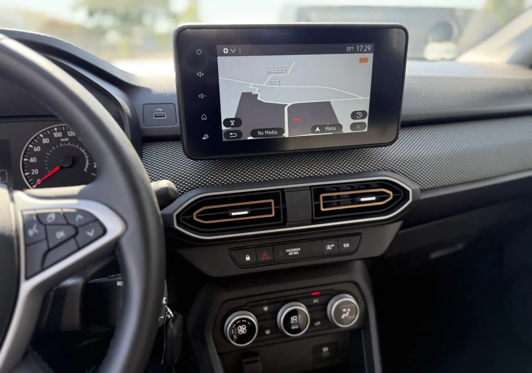 Vue intérieure du tableau de bord de la Dacia Sandero Stepway 2025 avec écran tactile GPS et commandes de climatisation.