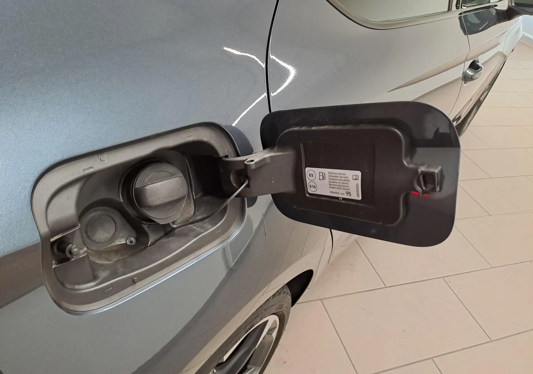Bouchon de réservoir ouvert côté gauche d'une CUPRA Leon 1.5 eTSI 150 ch gris magnétique 2023, essence.