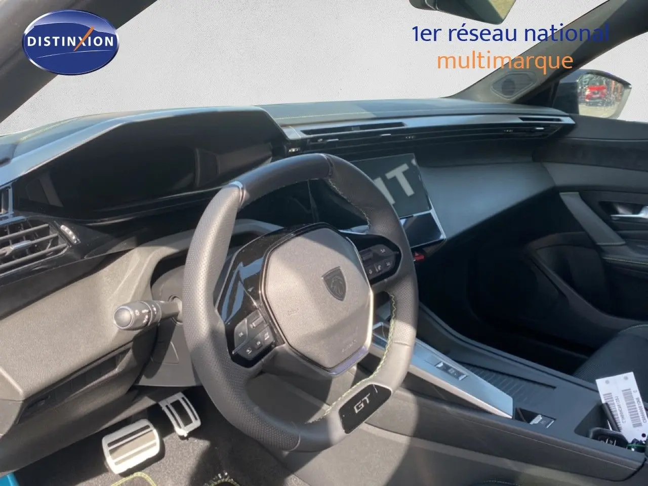 Vue intérieure côté conducteur du Peugeot 308 Hybrid blanc, mettant en valeur le volant GT et la console moderne.