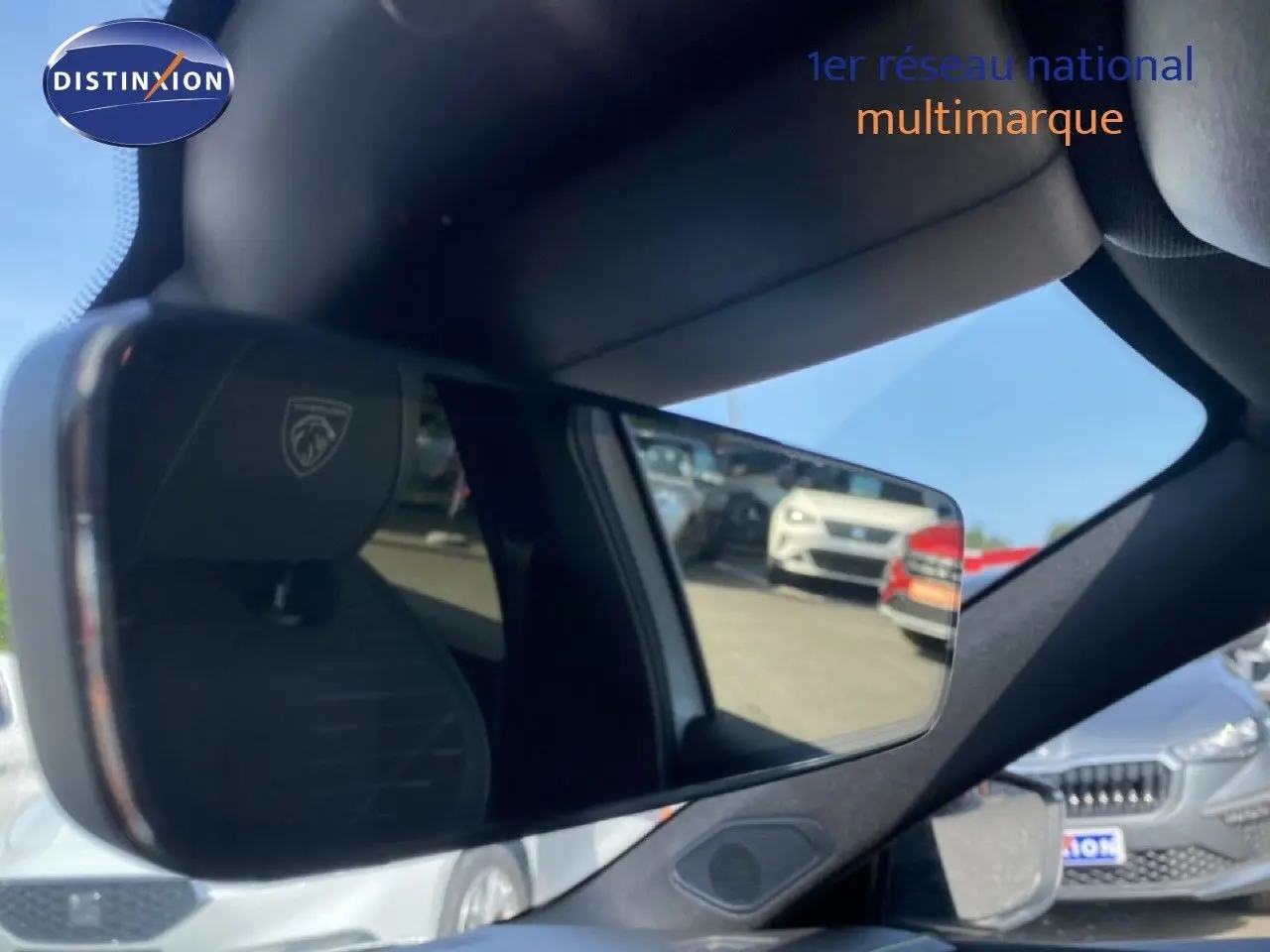 Rétroviseur intérieur de la Peugeot 308 Hybrid blanc Okenite, avec reflet du siège et vue partielle extérieure.