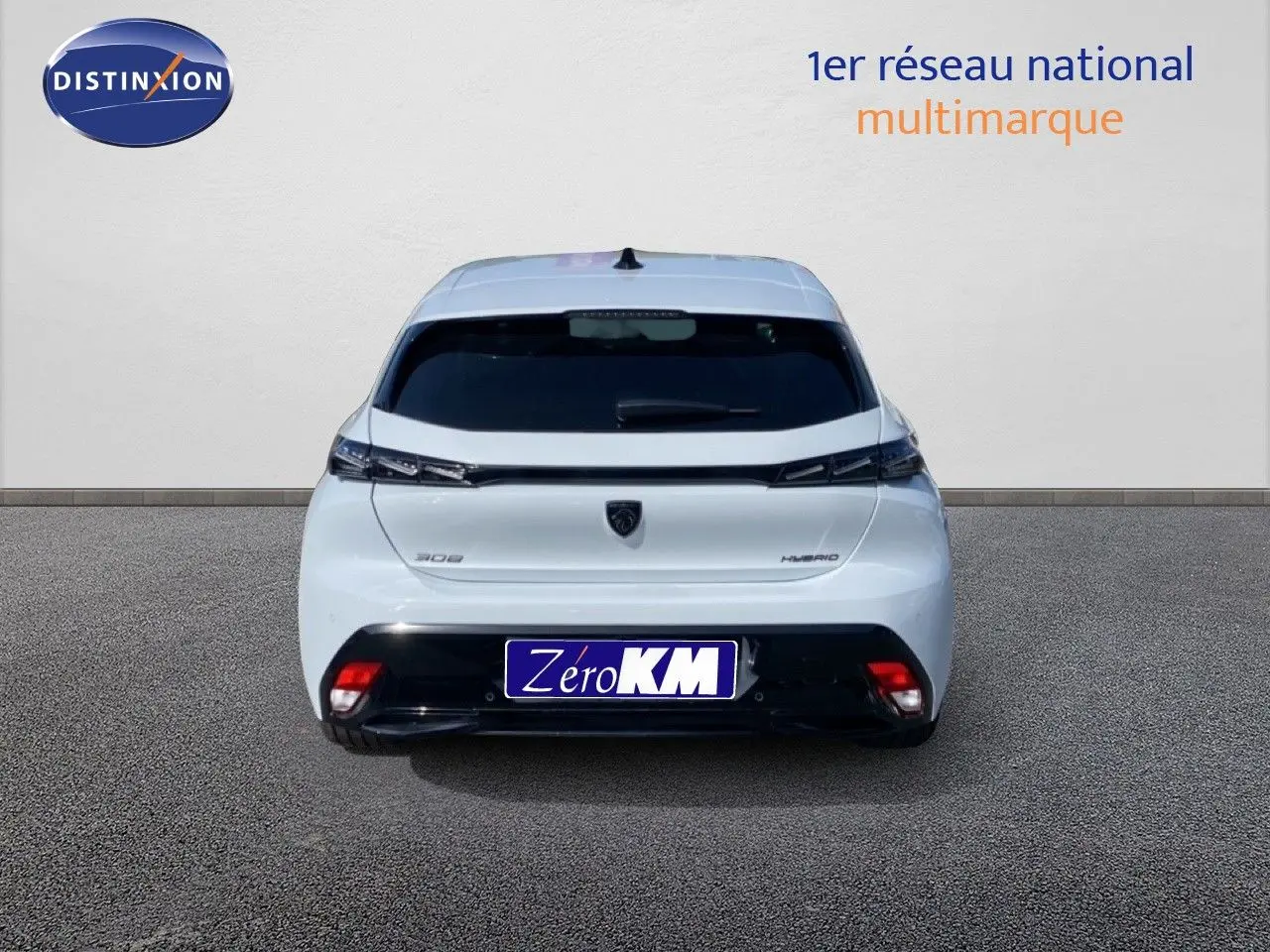 Vue arrière d'une Peugeot 308 Hybrid blanche Okenite Metal, avec feux effilés et logo central noir.