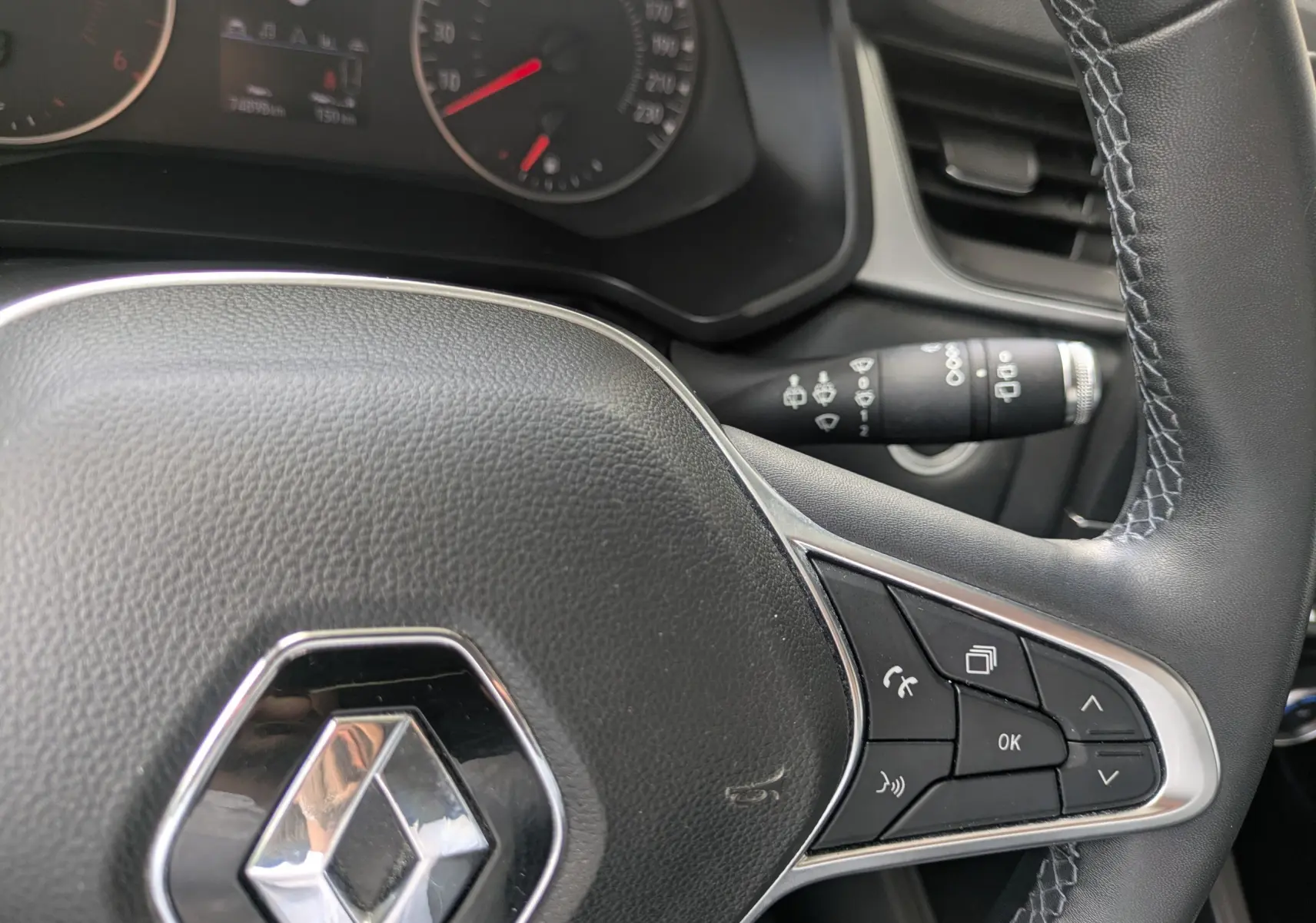 Gros plan sur le volant noir du Renault Captur Business DCI 95 de 2020, avec commandes intégrées et tableau de bord partiel.