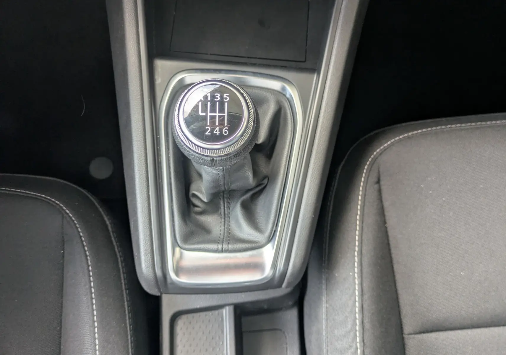Vue plongeante sur la console centrale du Renault Captur noir 2020, mettant en valeur le levier de vitesse manuel et les commandes de climatisation.